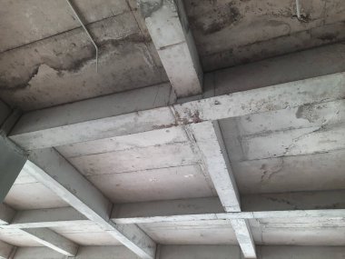 Tamamlanmamış bir binada güçlendirilmiş beton sütun ve kiriş yapısı biçimsel izler ve yapısal hizalama gösteriyor. Beton yapı, inşaat mühendisliği ve inşaat ilerleme teması için uygun