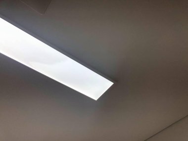 Modern bir ofis veya ticari bina içinde parlayan minimalist tavan LED panel ışığı. İç mimari temalar, ışıklandırma tasarımı, enerji tasarrufu ve modern binalar için elverişli