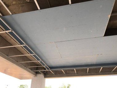 Mavi alçı taşı kurulumuna sahip metal tavan çerçeve yapısı, inşaat ve yenileme temaları için ideal