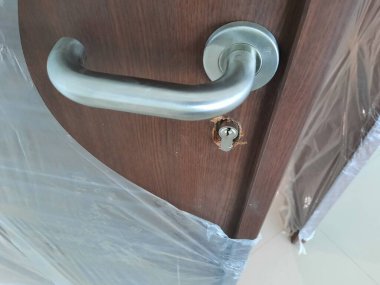 Ahşap kapının modern paslanmaz kapı kolu. Mimari ve iç donanım temaları için mükemmel