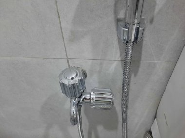 Banyo duvarında krom duş karıştırıcı musluğu, hortum bağlantısı, tesisat tesisatı. Tesisat sistemi, banyo içi, hijyen ürünleri ve ev eşyaları için elverişli