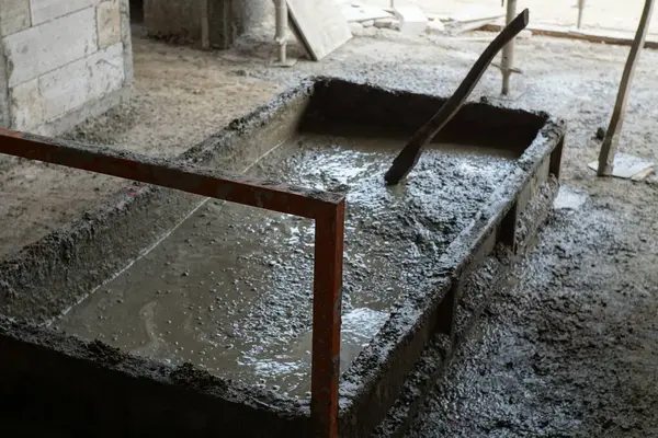 İnşaat sırasında inşaat alanında zemin seviyesindeki bir kalıpta ıslak beton karışımı. İnşaat mühendisliği, inşaat, çalışma süreçleri ve malzeme temaları için elverişli