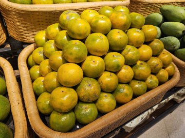 Yumuşak ışıkta çekilmiş taze portakal meyveleri doğal kusurları vurguluyor. Beslenme blogları, yemek dağıtım reklamları veya tarım temaları için ideal