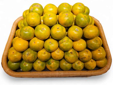 Tahta sepetin içinde yeşil-sarı portakal meyvesi. Sağlıklı beslenme kampanyaları, meyve pazarı görselleri ve turunçgiller için uygun. Beyaz arkaplanda izole