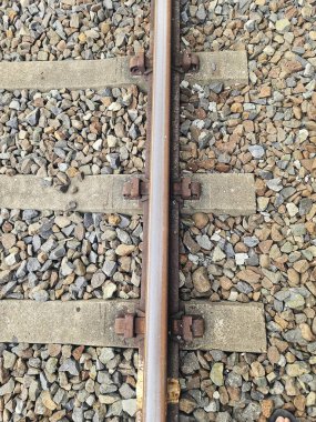 Demiryolu hatları beton kaplama ve kenarlar boyunca çimen ile birleşerek, taşımacılıkta birliği, altyapıyı ve yönü sembolize eder.