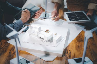 Enerji mühendisi profesyoneller, modelle çalışarak elektrik üretmek için saf enerji doğasını kullanma ve çatı katına güneş panelleri kurma hesaplamasını tartıştılar.