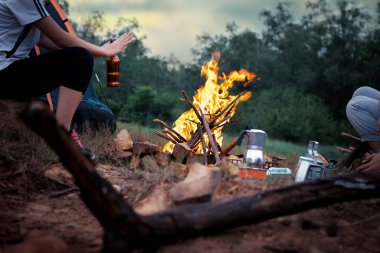 Kamp ateşinde kamp yapan insanlar dağların yakınında kamp yapıyorlar..