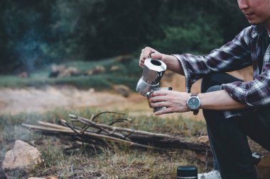 Hippi adam kahve molasına tek başına kahve koyar, kamp ateşinde kahve öğütücü elle işleme yapar, turizm kampı gezisi, kamp macerası....