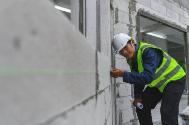 İnşaat mühendisleri inşaat binasındaki tuğla hatlarını incelemek için renk tendonları kullanıyorlar. İnşaat işlerini incelemek için kullanılan teknik.