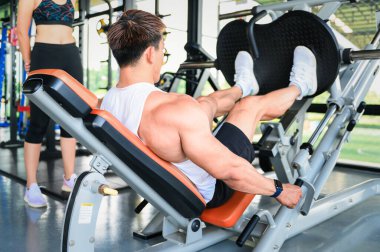 Spor salonunda genç bir bayana yardım eden kişisel antrenör ya da fitness eğitmeni.