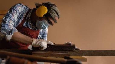 Marangoz, ahşap ahşap bir planör ya da marangozluk atölyesinde uçak aleti ile ahşap döşeme yaparken çok çalışır.