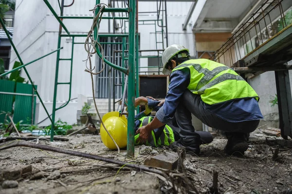 Accident of builder worker in work at construction site. Accident falls from the scaffolding on floor, Foreman support to help the employee body.