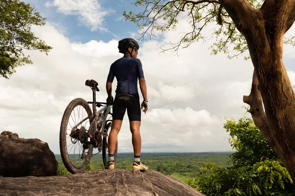 骑自行车的人站在石道上 山地自行车骑在山上 看起来是自然景观和天空的云彩 — 图库照片