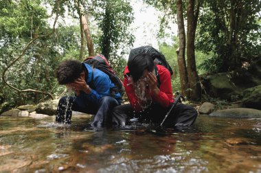İki genç yürüyüşçü ya da gezgin dağ nehrinde kayaların üzerinde oturur ve yüzünü dağ suyu ile yıkamak için ellerinde doğal su sıçratır. Uzun bir yolculuktan sonra kendine gelir..