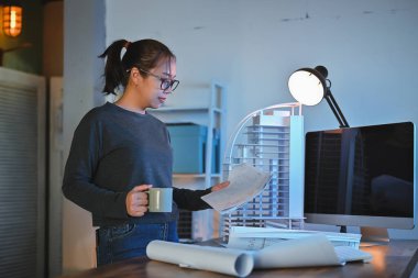 Sadece Asyalı mimar ya da kadın mühendis çalışma ayrıntıları ve inşaat tasarımı gece bir ofis odasında çalışma odasının üzerinde modelle birlikte..