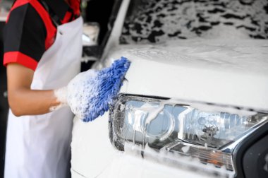 Erkek işçiler sabun yıkama ve araba bakımını özenle, araba yıkama ve araba yıkama ile otomotiv bakımı için parlak ve temiz araçları detaylandırmak için kullanır..