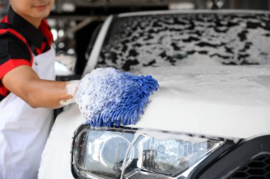 Erkek işçiler sabun yıkama ve araba bakımını özenle, araba yıkama ve araba yıkama ile otomotiv bakımı için parlak ve temiz araçları detaylandırmak için kullanır..