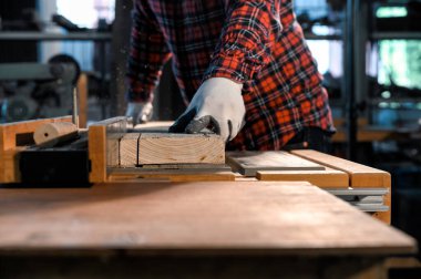 Marangoz atölyede ahşap kesmek için elektronik masa testeresi ile çalışıyor..