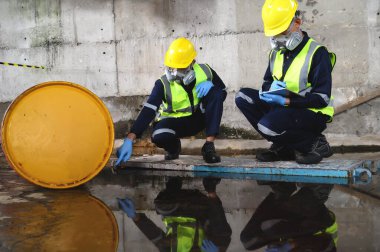 Çevre Mühendisliği 'nden iki memur gaz maskeli koruyucu ekipman giyip Depo Eski, Tehlikeli Yakıt Sızıntısı ve Çevre Konsepti' nde Petrol sızıntısı.
