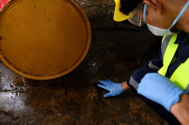 Officers of Environmental Engineering wearing masks inspected Oil Spill Contamination in Warehouse old, Hazardous Fuel Leakage and Environmental, Damage Industrial Accident Threatens. clipart