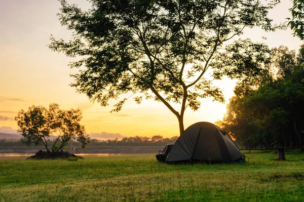 Camping black tent on grass nature in early morning or during sunrise beautiful view, golden morning light, Summer camping. Tourism with natural, Healthy freedom lifestyle and mental recreation.  **Focus**