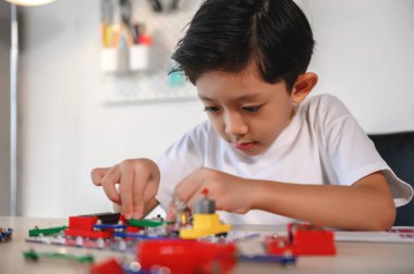 Asyalı Genç Çocuk Elektronik Yapıcı 'ya konsantre ol ve odaklan. Evdeki Devre Kuruluyla Öğrenme ve Deney. Geleceğin mucitleri için Beyin Geliştir, Uygula.