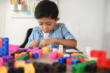 Asyalı Küçük Çocuk Evdeki Masada Renkli Plastik Küpler Oynuyor. Matematikte Sayma Küpü Öğrenme ve Eğitimi, Beyin ve Meditasyonu Oynarken Geliştirme.