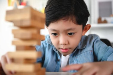 Çocuk Çocuk Evdeki Masada Jenga Oyunu Heyecan Veriyor. Eğlence ve Yetenek serbest bırakılıyor. Dikkatli ve özenli ol, konsantre ol ve oynarken yavaşça çıkar. Nesneleri çalıştır ve dengelemeyi öğren.