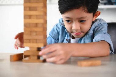 Çocuk Çocuk Evdeki Masada Jenga Oyunu Heyecan Veriyor. Eğlence ve Yetenek serbest bırakılıyor. Dikkatli ve özenli ol, konsantre ol ve oynarken yavaşça çıkar. Nesneleri çalıştır ve dengelemeyi öğren.