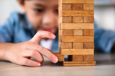 Çocuk Çocuk Evdeki Masada Jenga Oyunu Heyecan Veriyor. Eğlence ve Yetenek serbest bırakılıyor. Dikkatli ve özenli ol, konsantre ol ve oynarken yavaşça çıkar. Nesneleri çalıştır ve dengelemeyi öğren.