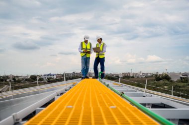 Profesyonel mühendisler ve Uzman teknisyenler Solar Photovoltaic panellerin kalitesini ve fabrika çatısı kapasitesini dizüstü bilgisayar ve tablet teknolojili uygulamalarla tartışıyor ve kontrol ediyorlar..