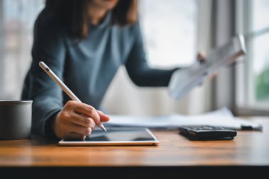 Alternatif enerji mühendislerinin yakın çekim elleri fotovoltaik panellerde fotokopi alanı ile kurulmuş enerji birikimi için tasarım ve hesaplama için teknoloji tableti kullanıyorlar..