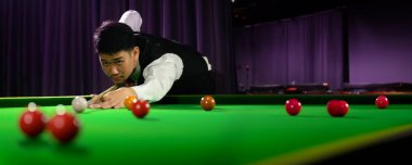 Bilardo masasındaki kırmızı topa vurmak için beyaz top atarken Asyalı bilardo oyuncusunun portresi. Kopyalama alanı olan pankart boyutu.