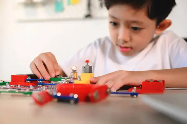 亚洲幼儿有乐趣和享受与连接的电子建设者 在家与电路板一起学习和实验 开发大脑 为未来创新者实践发明 — 图库照片