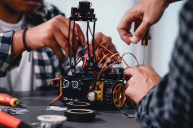 Robot malzemeleri monte eden Asyalı Mühendis Öğrenciler. Mekanik Kontrol 'ü öğrenirken, robotlar bilgisayar, elektrik, mekanik ve algılamayı birleştirir. Mühendisleri ve Geliştirme Konseptini Güçlendirme.