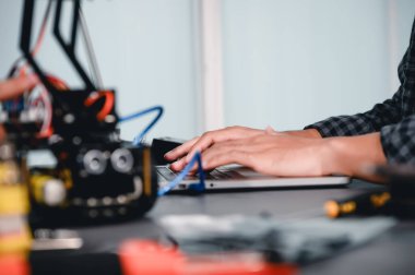 Robot malzemeleri monte eden Asyalı Mühendis Öğrenciler. Bilgisayar tarafından mekanik kontrol öğrenme, robotlar bilgisayar, elektrik, mekanik ve algılamayı birleştirir. Mühendisleri ve Geliştirmeyi Güçlendiriyor.