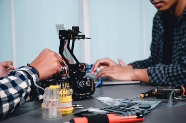 Robot malzemeleri monte eden Asyalı Mühendis Öğrenciler. Mekanik Kontrol 'ü öğrenirken, robotlar bilgisayar, elektrik, mekanik ve algılamayı birleştirir. Mühendisleri ve Geliştirme Konseptini Güçlendirme.