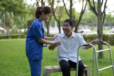 Asyalı Kadın Doktor Yaşlılara Yardım Ediyor ve Tedavi Süresinde Cesaret Veriyor. Yürüyen Aids 'li Asyalı Emekli Hastaların Rehabilitasyon veya Fiziksel Terapisi.