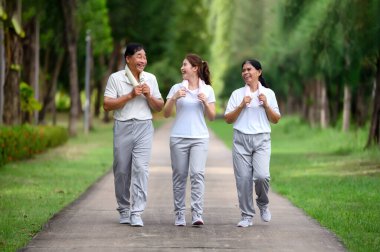 Asyalı Yaşlılar ve Kızları Park 'ta Koşu ve Rahatlama, Doğada Aile Bağları, Yaşlılar ve Aileler Yeşil Park' ta Egzersiz ve Rahatlama, Sağlık ve Aile Bağları Konsepti