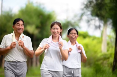Asyalı Yaşlılar ve Kızları Park 'ta Koşu ve Rahatlama, Doğada Aile Bağları, Yaşlılar ve Aileler Yeşil Park' ta Egzersiz ve Rahatlama, Sağlık ve Aile Bağları Konsepti