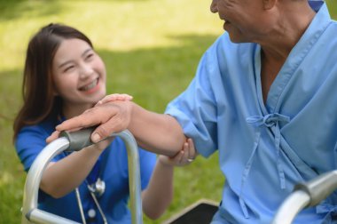 Fiziksel Sağlık Rehabilitasyonunu sürdürürken kıdemli hastanın Asyalı Kadın Doktoru Teşvik Etme Eli..