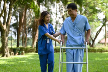 Asyalı Kadın Doktor Kıdemli Hastaya Yardım Ediyor ve Tedavi sırasında Teşvik Ediyor. Yürüyen Aids 'li Asyalı Emekli Hastaların Rehabilitasyon veya Fiziksel Terapisi.