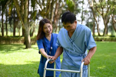 Asyalı Kadın Doktor Kıdemli Hastaya Yardım Ediyor ve Tedavi sırasında Teşvik Ediyor. Yürüyen Aids 'li Asyalı Emekli Hastaların Rehabilitasyon veya Fiziksel Terapisi.