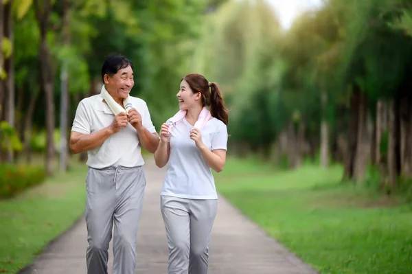 亚洲老年人和女儿在公园慢跑和放松 大自然中的家庭粘合 老年人和家庭享受运动以及绿园中的放松 保健和家庭粘合概念 — 图库照片