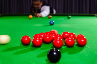 Beyaz bir bilardo topunun aksiyon sahnesi bir grup kırmızı bilardo topuna çarpar. Snooker oyuncuları oyununu başlatmak için.