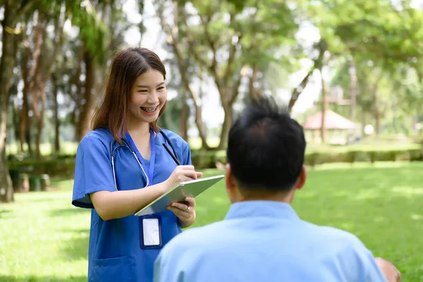 Asian Young Female Doctor Talking and Questions to Health with Senior Patients, List Notes to Health Condition, Patient\'s Healthcare Provider, Rehabilitation or Physical Therapy of Retired Patients.
