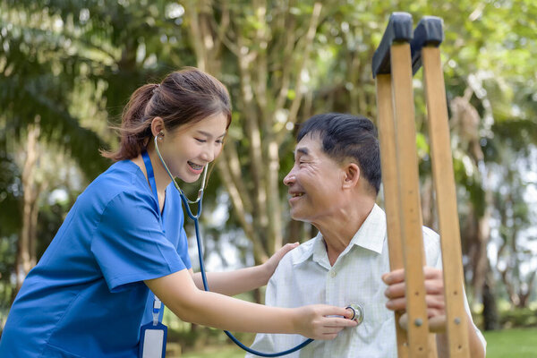 Asian Young Female Doctor Check Older Adult Health Condition and Provide Encouragement During Treatment. Rehabilitation or Physical Therapy of Asian Retired Patients.