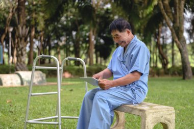 Kızı, hastanede iyileşmekte olan babasına yardım ediyor. İletişim teknolojisi tabletleri kullanarak. Hastane parkındaki aile üyeleriyle iletişim kurun..