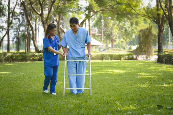 Asian Young Female Doctor Help Support Senior Patient and Provide Encouragement During Treatment. Rehabilitation or Physical Therapy of Asian Retired Patients with Walking Aids.