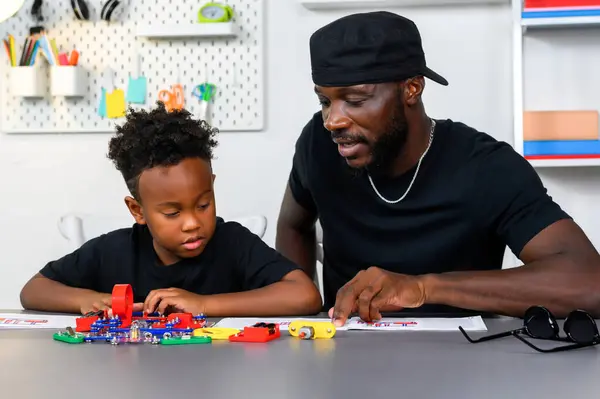 Father teaches and helps his son study how to wire an electrical circuit at home. Parental guidance, Homeschooling and being a learning buddy.